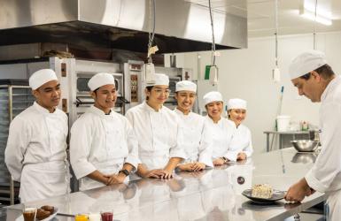 A chef teaching international students to cook in a commercial kitchen in Northern Territory