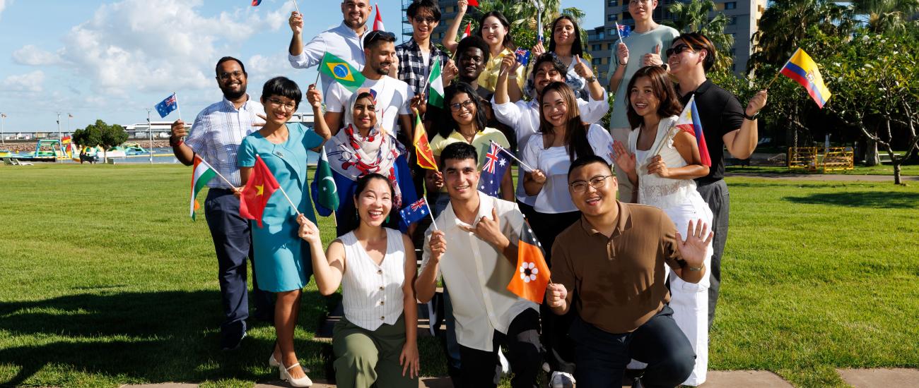 A group of international students from different countries waiving with their country flags